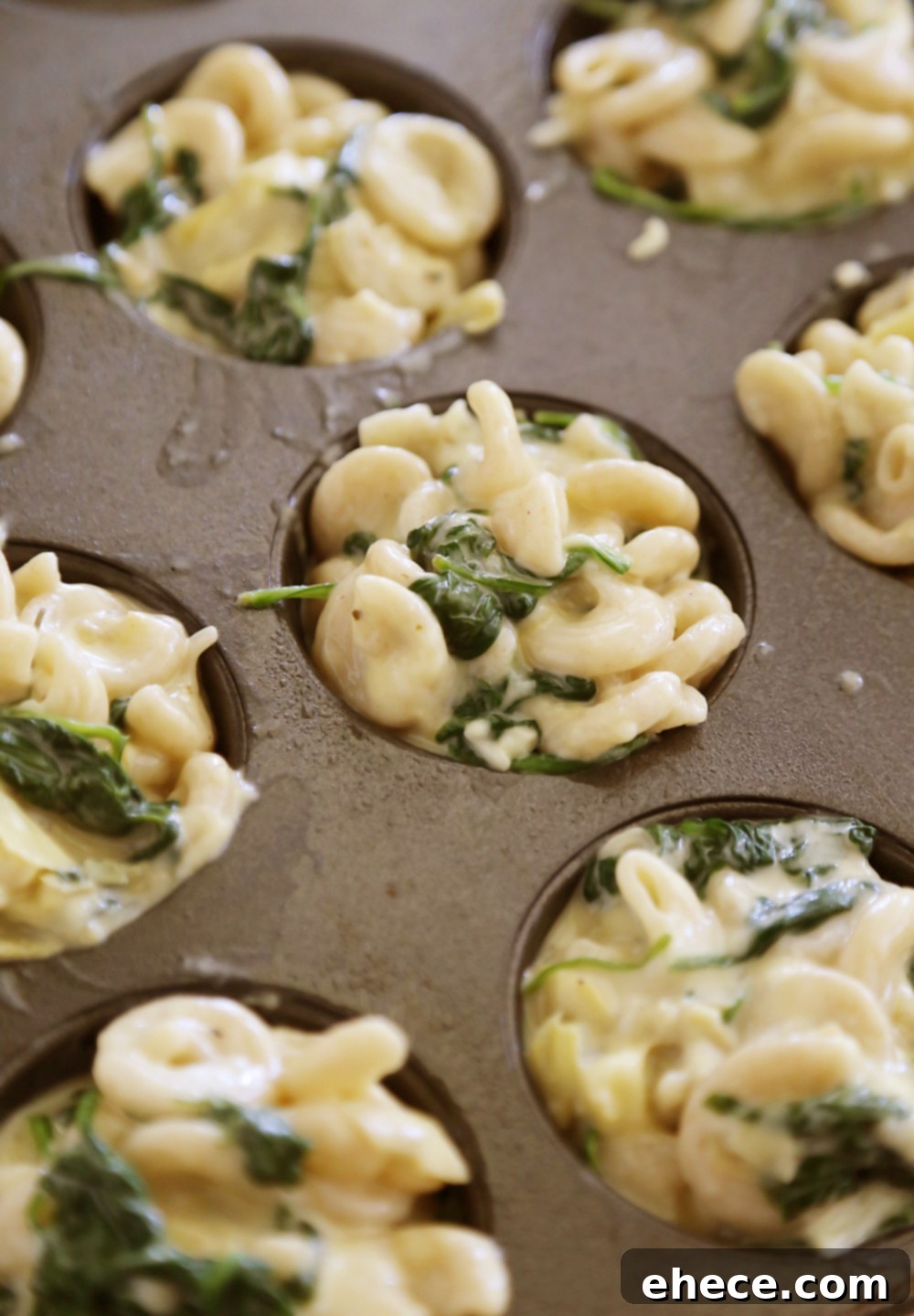 Creamy Spinach Artichoke Mac and Cheese Bites 4 A plate of Spinach and Artichoke Macaroni and Cheese Bites, ready to be served as an appetizer at a party. They look inviting and perfectly portioned.