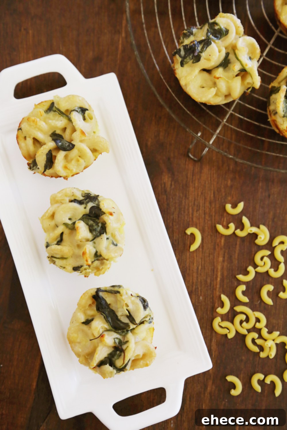 Creamy Spinach Artichoke Mac and Cheese Bites 5 Hand holding a single Spinach and Artichoke Macaroni and Cheese Bite, showcasing its handheld convenience and appealing texture.