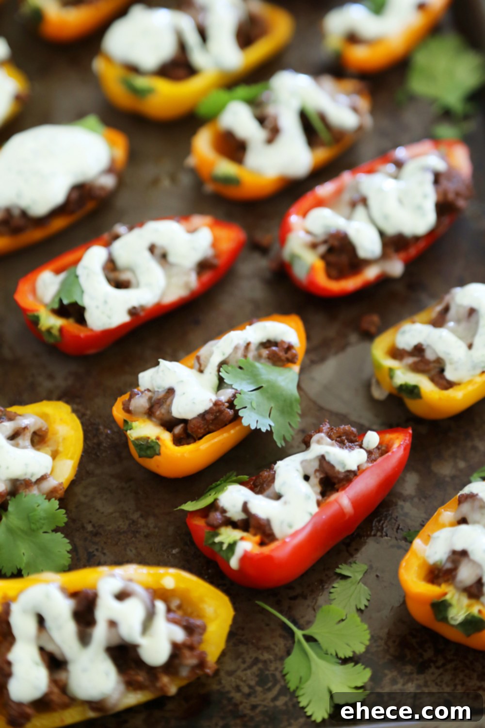 Closeup of a single Mini Taco Stuffed Pepper topped with cilantro cream sauce, highlighting the texture.