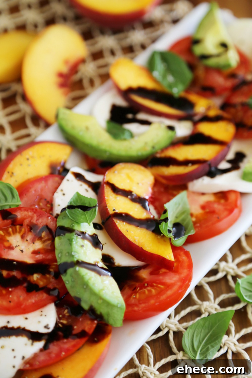 Sun-Kissed Peach and Avocado Caprese 6 Top-down view of Peach and Avocado Caprese Salad, showcasing the fresh basil and balsamic drizzle. Thecomfortofcooking.com