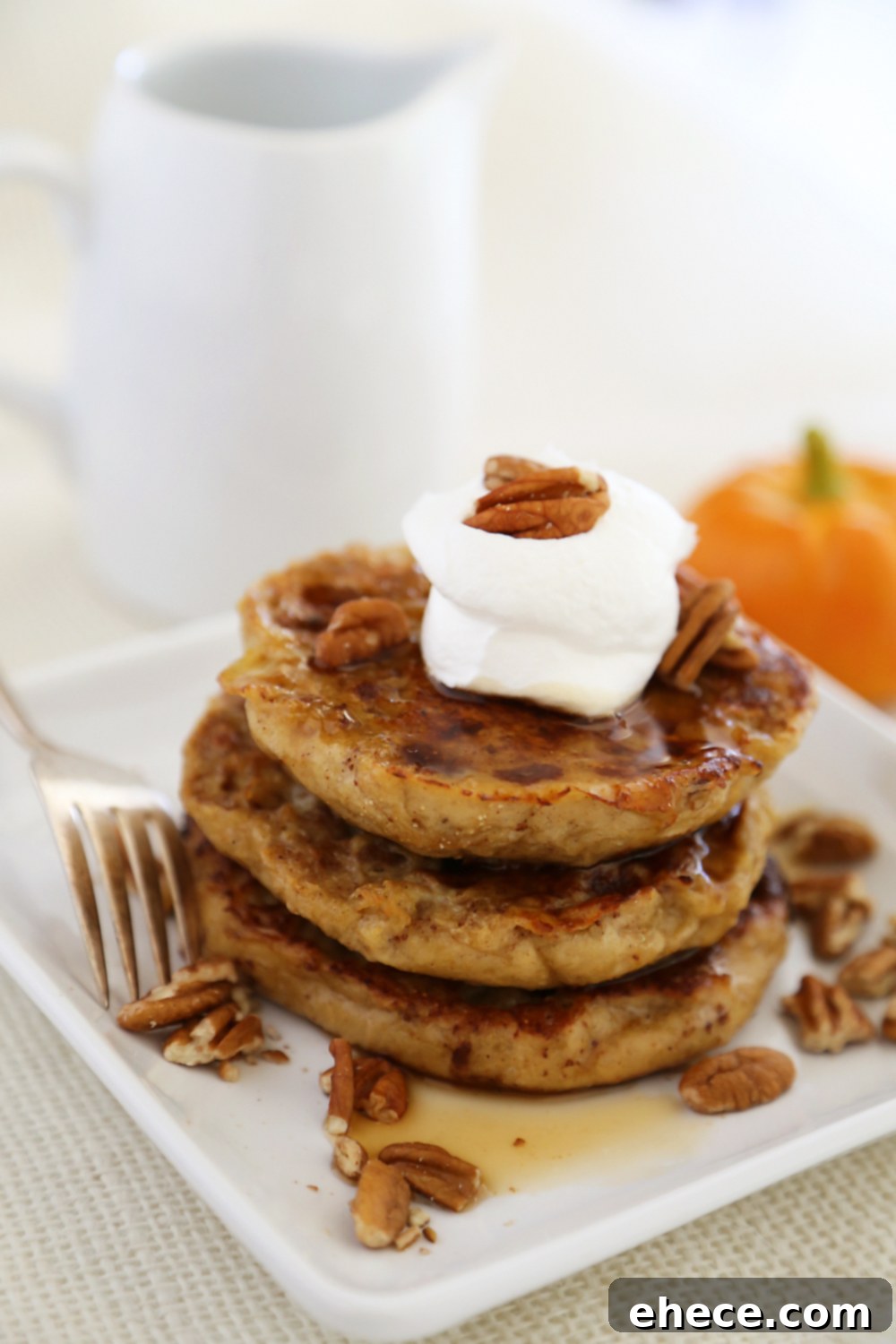Fluffy, buttery Pumpkin Spice English Muffin French Toast, perfect for a fall breakfast or brunch. Served with whipped cream and pecans.