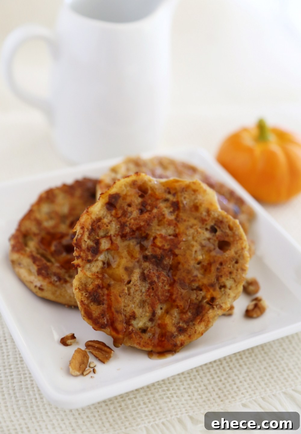 Close-up of golden-brown Pumpkin Vanilla English Muffin French Toast on a skillet, showing the perfectly cooked edges.