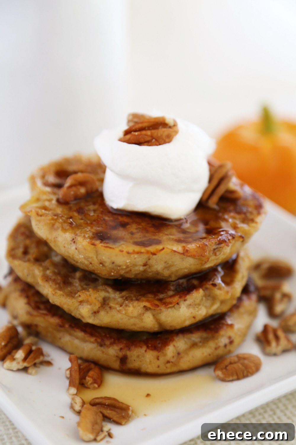 Top-down view of Pumpkin Vanilla English Muffin French Toast with a generous pour of maple syrup, ready to be enjoyed.