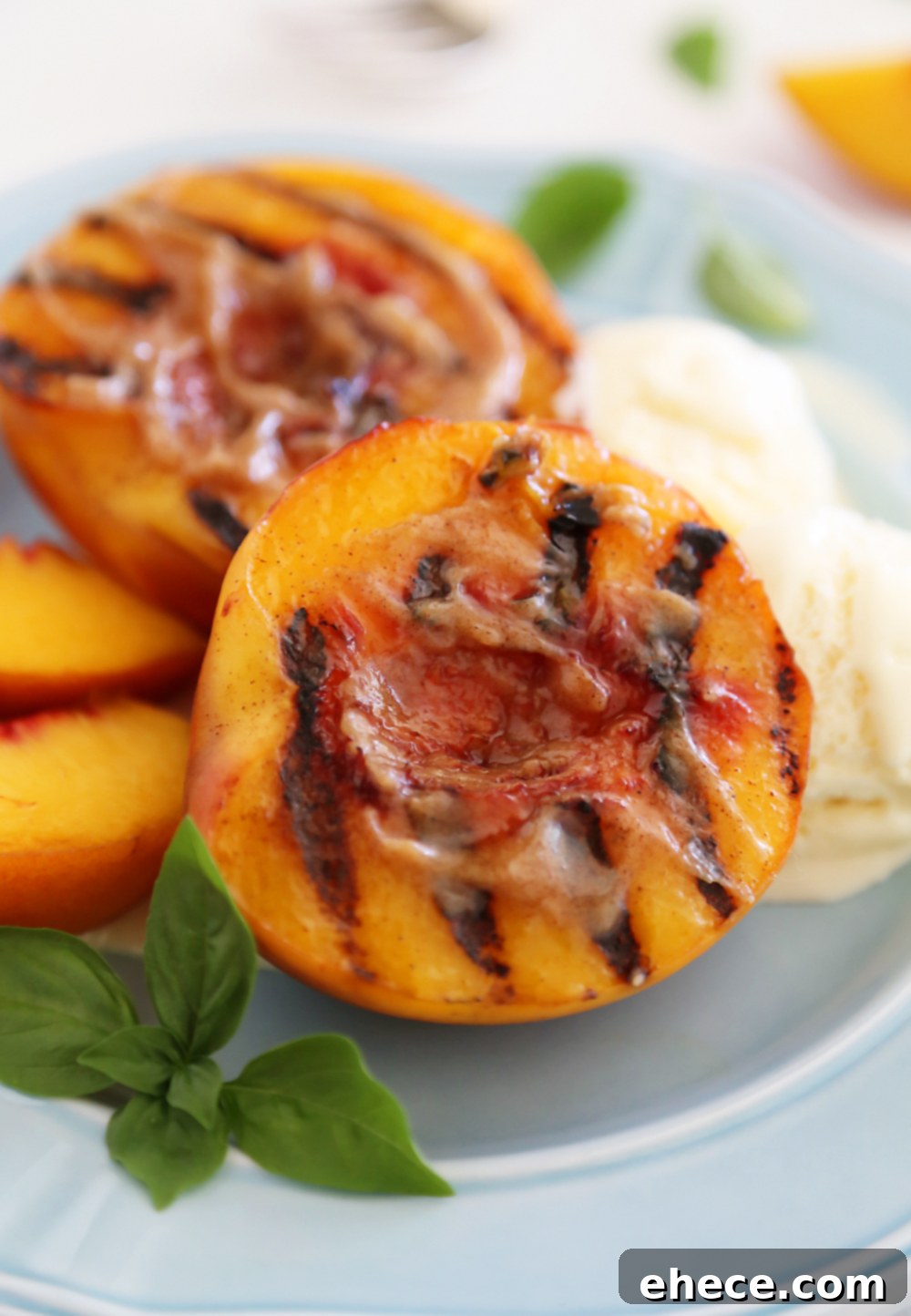 Close-up of a grilled peach half with golden brown char marks, glistening with melted butter, ready to be served.